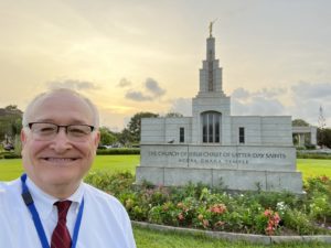 Bob Jacobs smiling in front of church on sunny day in Africa