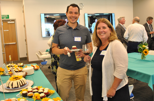 man and woman in front of dessert table at cocktail party
