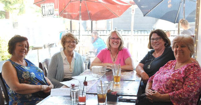 five women around luncheon table with beverages
