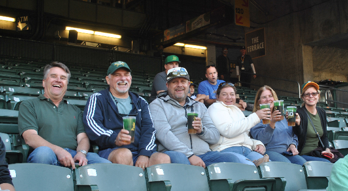 six people in the stands at the A's game smiling, happy