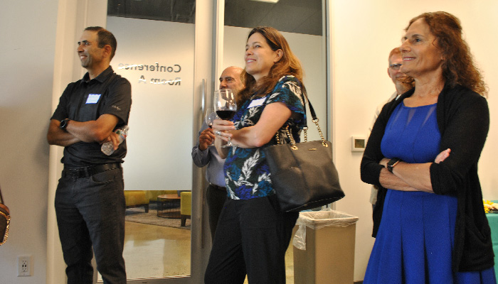 Three people listening to speaches, with arms crossed