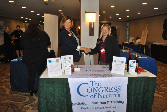 Two women shake hands from the Congress of Neutrals 