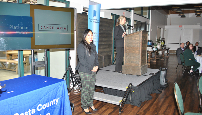 Smiling woman before receiving Diversity Award with woman on poedium.