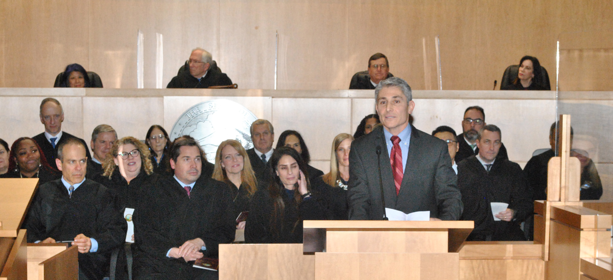 Man speaks from podium in front of judges