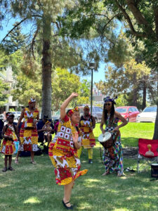 A woman in West African dress dances at Pleasant Hill Park.